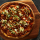 Hot chicken pizza on a wooden cutting board